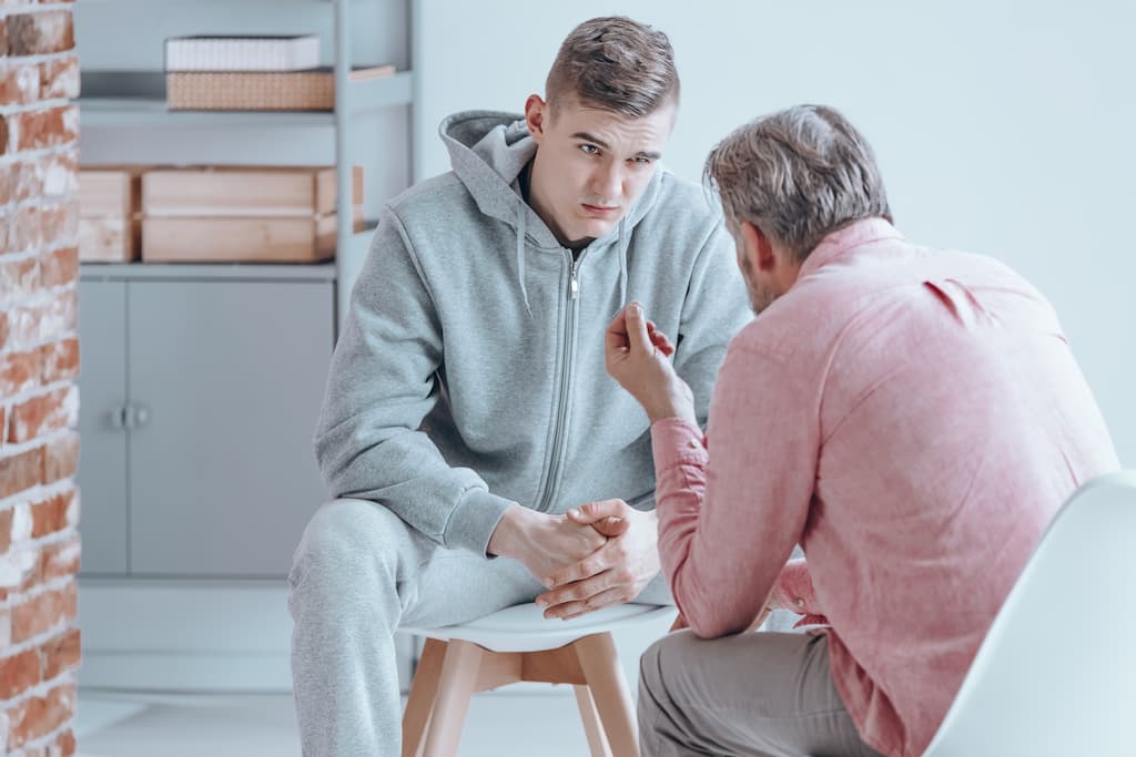 Pai conversando com filho rebelde na adolescência